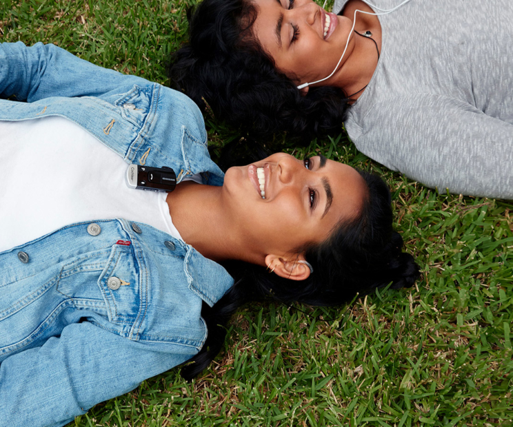 girls listening to music laying on ground