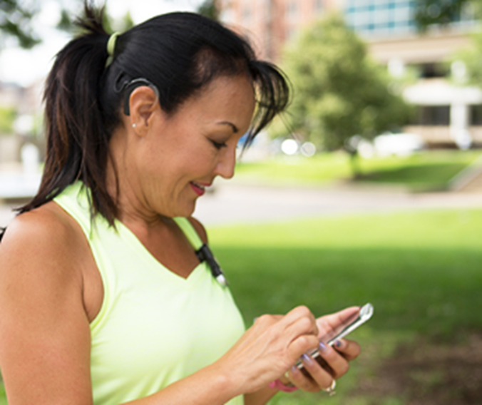 woman with cochlear implant on run with phone